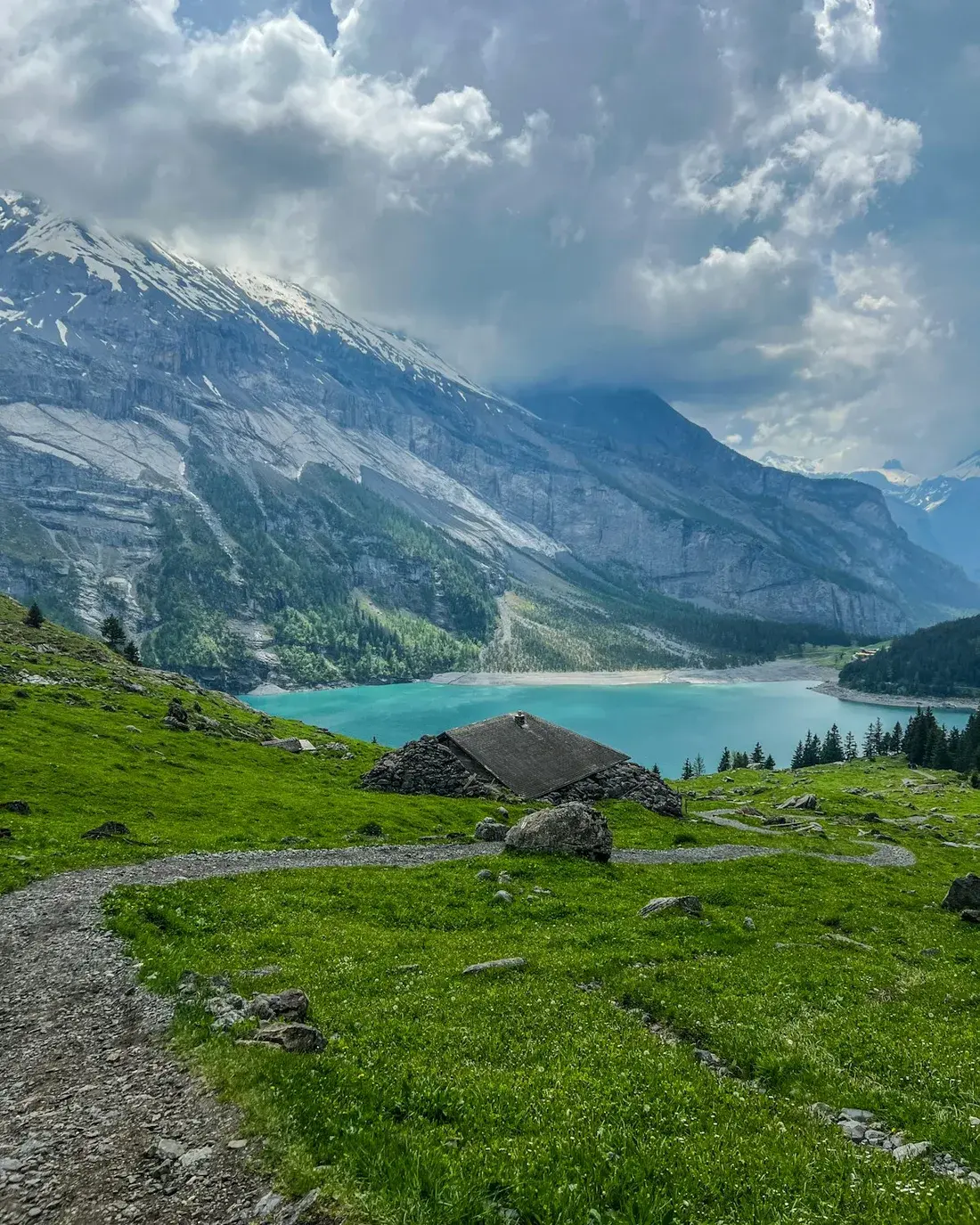 A walking trail overlooking the turquoise water of Oeschinen Lake